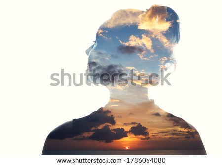 Double exposure portrait of a woman in contemplation at sunset time