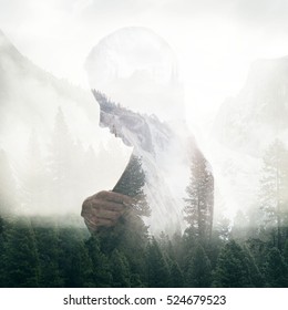 Double Exposure Portrait Of A Young Thoughtful Woman Combined With Photograph Of Green Forest Trees In Mountains. Conceptual Image Showing Unity Of Human With Nature. Ecology, Freedom, Environment