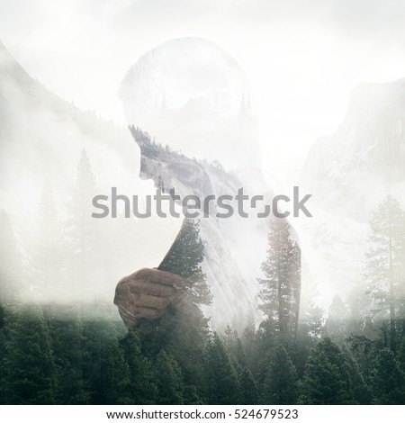 Double exposure portrait of a young thoughtful woman combined with photograph of green forest trees in mountains. Conceptual image showing unity of human with nature. Ecology, freedom, environment