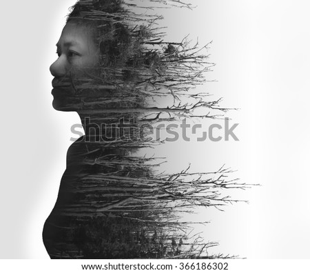 Double exposure portrait of young woman and dead forest in black and white
