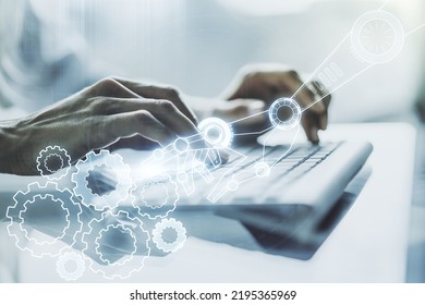 Double exposure of robotics technology hologram and hands typing on laptop on background. Research and development software concept
