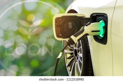 Double exposure sign ECON and EV Car or Electric car at charging station with the power cable supply plugged in on blurred nature with soft light background. Eco-friendly alternative energy concept.  - Shutterstock ID 1112518985