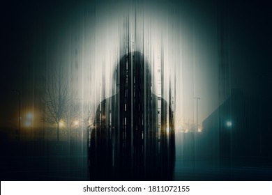 A double exposure of a Silhouette of a mysterious hooded figure without a face, in a city at night. With a glitch, edit - Shutterstock ID 1811072155