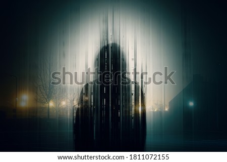 A double exposure of a Silhouette of a mysterious hooded figure without a face, in a city at night. With a glitch, edit