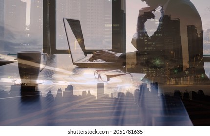 Double exposure silhouette of successful businessman is working at office desk. Thoughtful entrepreneur using laptop computer in a modern futuristic setting. 
 - Powered by Shutterstock