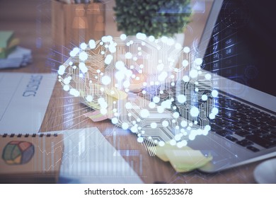 Double exposure of table with computer and brain hologram. Data innovation concept.