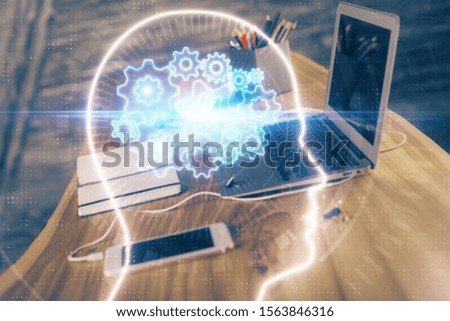Double exposure of table with computer and brain hologram. Data innovation concept.