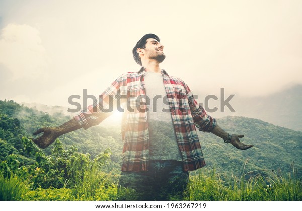Double exposure of tourist caucasian\
man raise your hands to breathe pure air with\
mountain.
