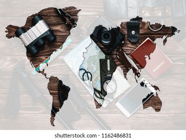 Double exposure of travel objects with map of world on wooden background, top view.