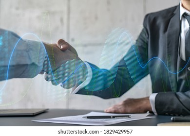 Double exposure of two businesspeople handshake and financial chart hologram drawing background. Concept of partnership in business and data analysis. Formal wear.