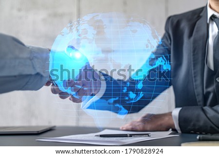 Double exposure of two businesspeople handshake and globe the earth hologram drawing background. Concept of international business. Formal wear.