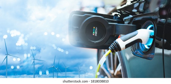 Double Exposure Of Vehicle Electric Car Charge Battery With Wind Turbine And Blue Sky Blur Bokeh On Panoramic Background. Idea Nature Electric Energy To Generate Electricity. Green Energy Eco Concept.