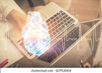 Double exposure of woman hands typing on computer and heart hologram drawing. Education concept.
