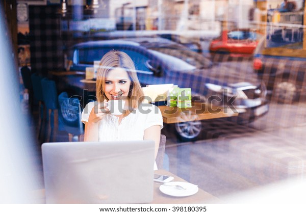 Double exposure, woman with notebook in cafe\
drinking coffee