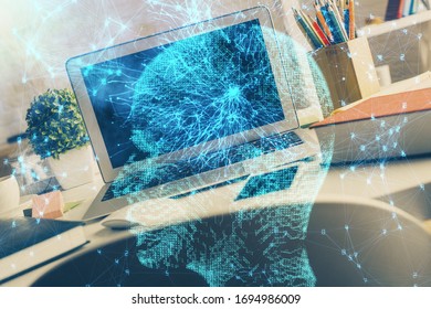 Double exposure of work space with computer and human brain drawing hologram. Brainstorm concept.