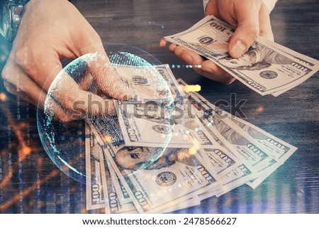 Double exposure of world map drawing hologram and us dollars bills and man hands.