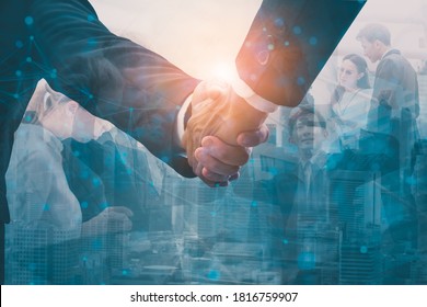 Double exposure-Industry investment,telecommunication business concept,businesspeople team join handshake,negotiate mergers and acquisitions,urban cityscape and skyscrapers,visible wireless network - Powered by Shutterstock