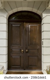 Double Front Doors Surrounded By Stone Arch With Overhead Window