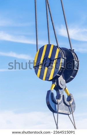 Double hook of a port crane close-up on a blue sky background