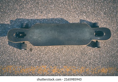 double kick cutaway longboard on asphalt without people, evening photo