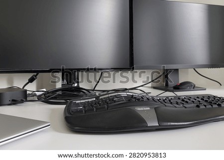 Double monitors with computer laptop, ergonomic keyboard, mouse and docking station. Home workdesk concept. Advanced dual screens.