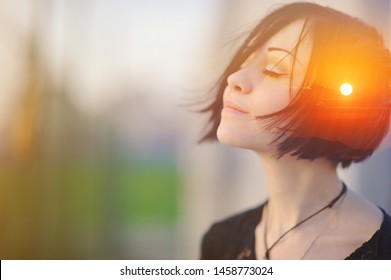 Double multiply exposure portrait of a dreamy cute woman meditating outdoors with eyes closed, combined with photograph of nature, sunrise or sunset, closeup. Psychology freedom power of mind concept