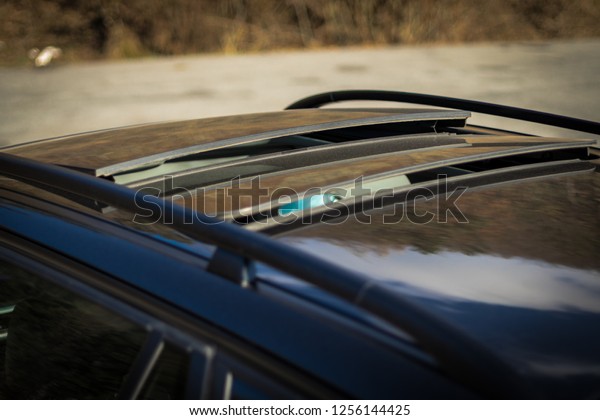 Double panoramic glazed dach\
open sunroof outside view. Tilted, open hatch - luxurious modern\
car isolated photo session in a parking lot. Close up photo,\
detailed.