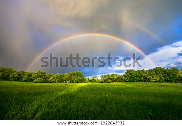 Double rainbow during the coming storm over the\
Czech green spring\
landscape