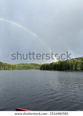 Double rainbow located on tedious lake in Ontario, Canada. Beautiful greenery and blue grey water.