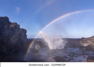 Double rainbow over Nakalele blowhole. Sunrays reflect on a spray coming from a blowhole creating beautiful color stripes