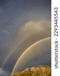 A double rainbow over Stellenbosch Mountain against a cloudscape