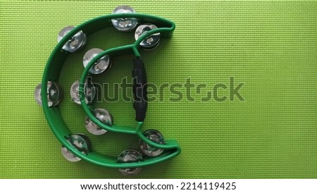 double row handle tambourine isolated on green background. jingles hand held percussion.