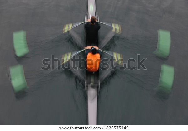 Double scull pairs boat, two oarsman in a\
sculling boat on the water, mid\
stroke.