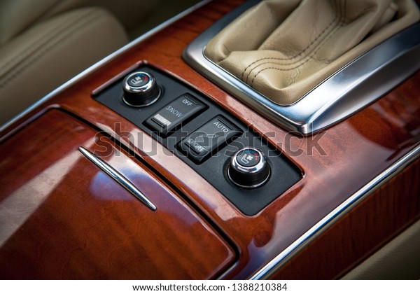 Double seat heating Switch in luxury car. Close up
shot of modern central console with steering heating controls,
Suspension and traction control Ventilated seats for summer. Wood
and leather dash