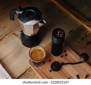 Double Shot Espresso With Hand Grinder, Moka Pot And Some Coffee Beans On Rustic Wooden Background In A Dark Mood.