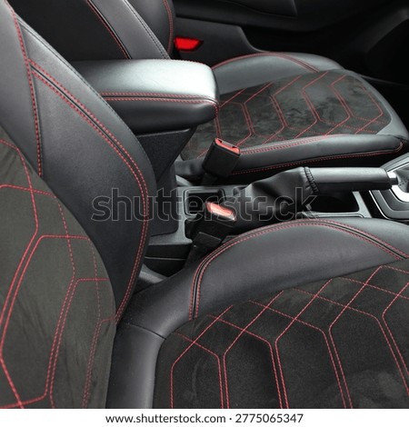 Double stitching with red threads alcantara trimming of seats in modern car 
