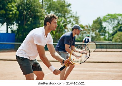 Double trouble. Shot of two tennis players on the.same team waiting for the ball.
