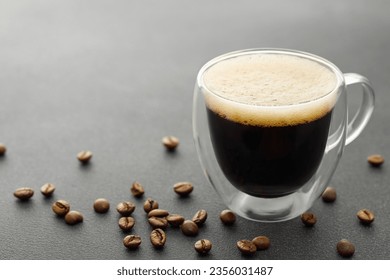 double wall glass cup of espresso and coffee beans on grey table - Powered by Shutterstock