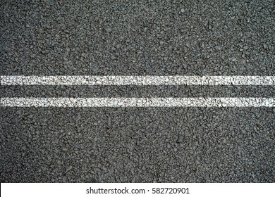Double white lines on the asphalt road in the middle.
