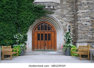 double wooden front door with leaded glass and ivy covered stone wall of  college building - Powered by Shutterstock