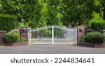 Double wrought-iron gate. Wrought iron gate and stone pillar. White wrought iron entrance gates to rural property. Nobody, street photo