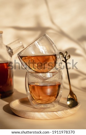 Double-bottom glasses are stacked on top of each other. Natural motives in warm colors. Breakfast glasses with tea. A spoon in the shape of a leaf. 