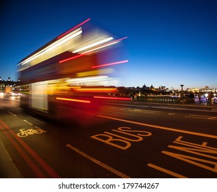 Double-Decker Bus Crossing Westminster Bridge At Night In London, England