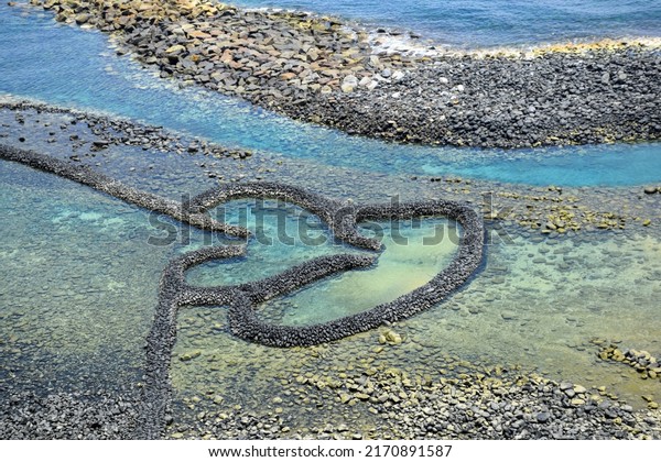 Double-Heart\
of Stacked Stones or the Twin-Heart Fish Trap bathed in the\
beautiful sea water, which is a fishing weir and now a popular\
tourist attraction in Chimei, Penghu,\
Taiwan