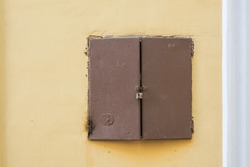 The Double-leaf Old Metal Door Is Locked With A Padlock. There Is A Plastered Wall Of An Old Building. Background. Form.