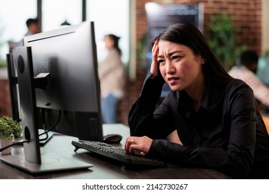 Doubtful Asian Computer Engineer Puzzled By Nonfunctional Security Algorithm And Company Corrupted Database. Confused Uncertain Programmer Sitting At Computer Trying To Solve Network Processing Errors