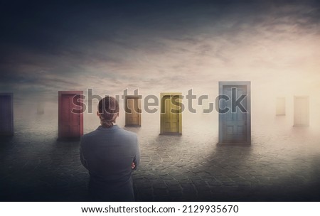 Doubtful businessman in front of multiple doors of diverse colors as symbol for different opportunities. Business challenge, choosing a correct doorway. Difficult decision concept, failure or success