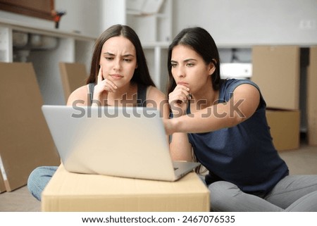 Doubtful roommates checking laptop content and taking decisions moving home