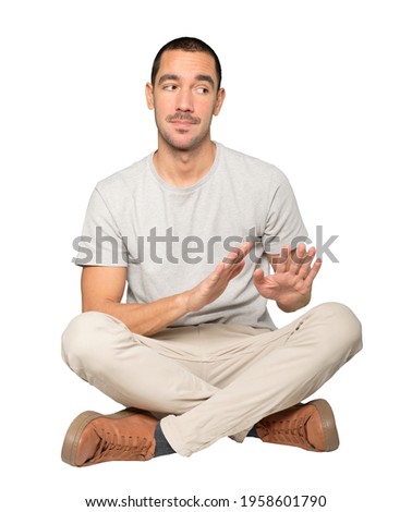 Doubtful young man doing a gesture of keep calm