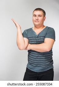 Doubtful young man sitting and gesturing with hands